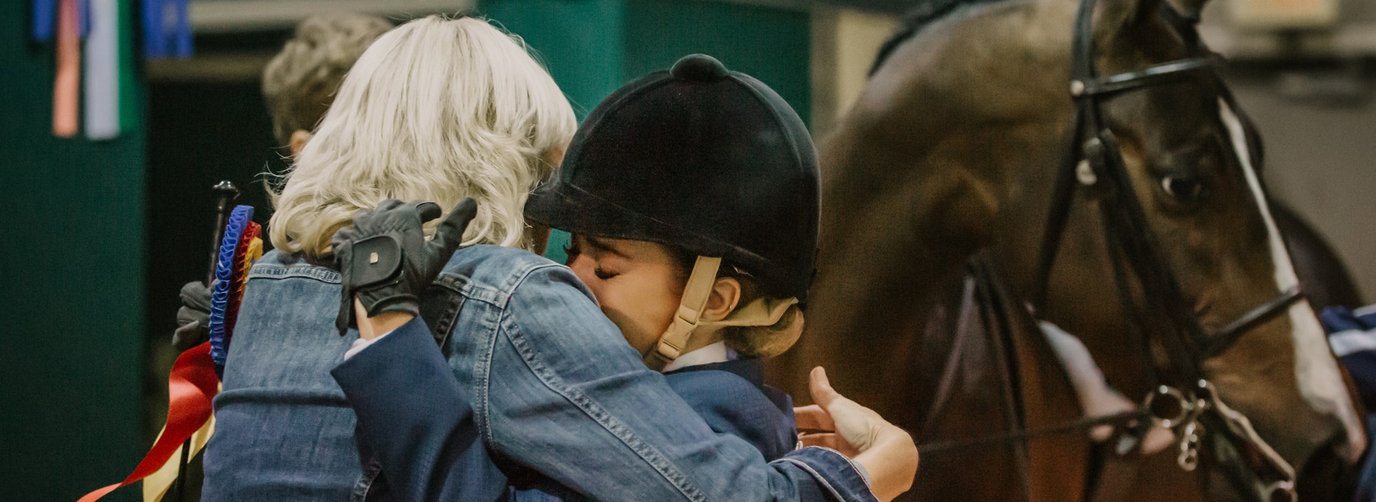 Two people hugging with Morgan horse begin them