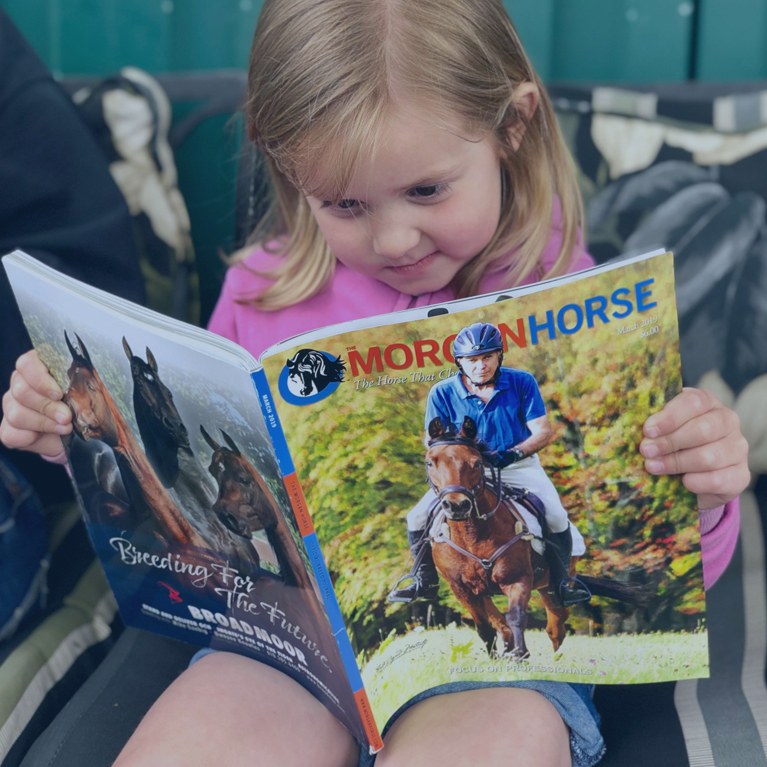 Little girl reading the magazine